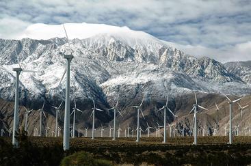 Windmills in front of snowy mountains